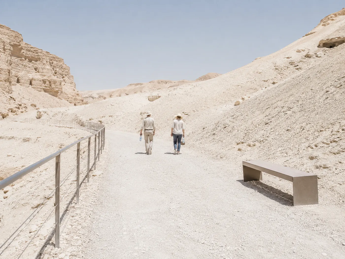 ضباب حر الظهيرة فوق طريق خالٍ، مقعد، ولا يوجد ظل في أي مكان في الإطار